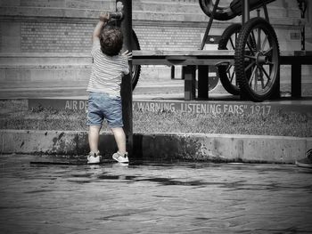 Rear view of woman with umbrella in water