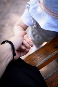 Midsection of couple holding hands