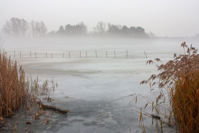 Scenic view of frozen lake against sky during winter