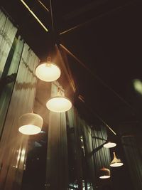 Low angle view of illuminated pendant lights hanging from ceiling