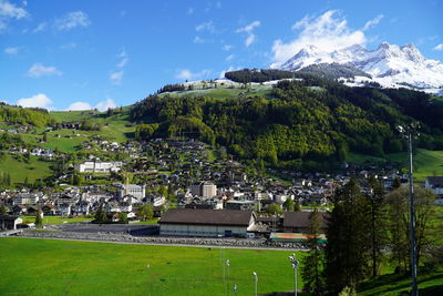 Scenic view of houses by mountains against sky