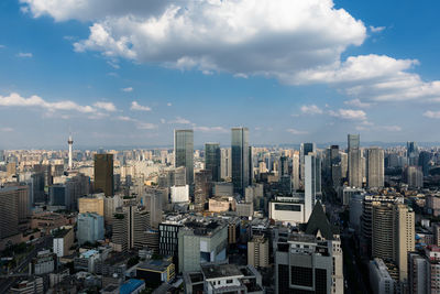 Aerial view of buildings in city against sky