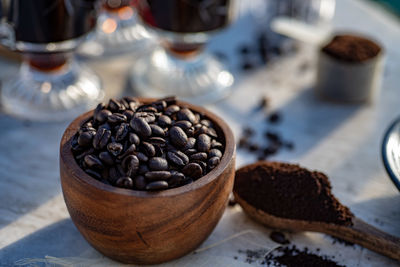 Still life with coffee beans, ground coffee, wooden spoon, coffee pot, scoop, making coffee at home