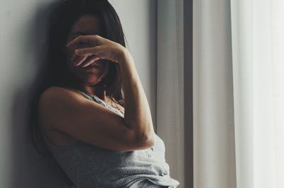 Woman sitting by window at home