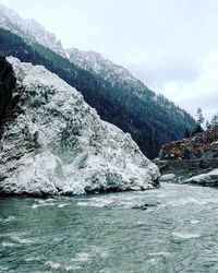 Scenic view of river and mountains against sky