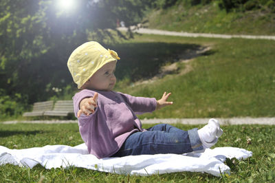 Rear view of boy sitting on field