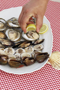 Man squeezing fresh lemon juice on oysters and mussels