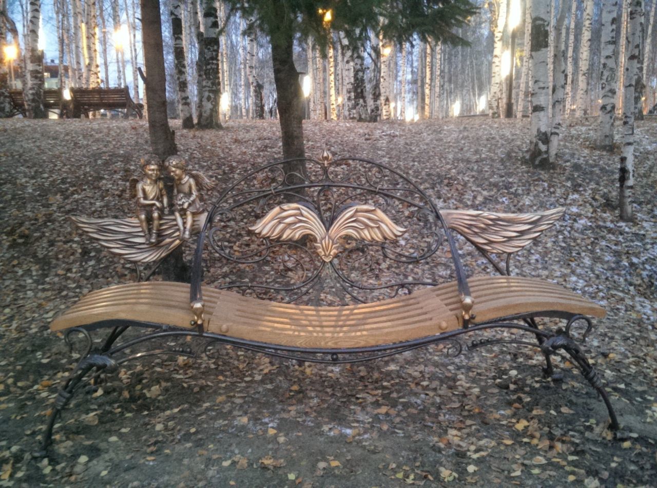 tree, tree trunk, chair, wood - material, absence, sunlight, day, no people, tranquility, outdoors, park - man made space, art and craft, empty, religion, old, nature, built structure, art, bench, forest