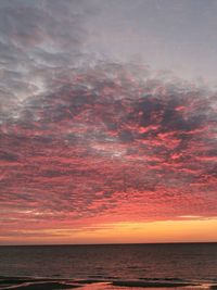 Scenic view of sea against dramatic sky during sunset