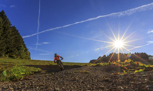 Man with bicycle against blue sky