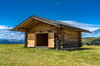 Built structure on field against clear blue sky