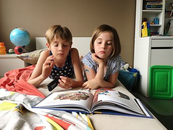 Siblings sitting on book