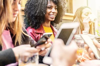 Portrait of smiling young woman using smart phone outdoors
