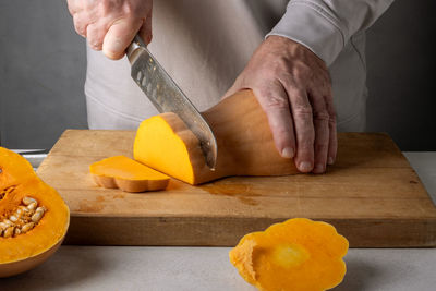 Midsection of chef preparing food on cutting board