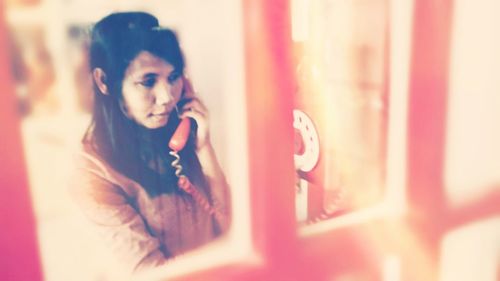 Close-up of young woman using mobile phone at home