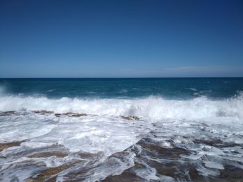 Scenic view of sea against clear blue sky