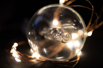 Close-up of crystal ball on table against black background
