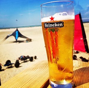 Close-up of beer on table at beach