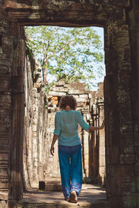 Rear view of woman walking amidst trees