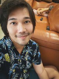 Portrait of smiling young man sitting outdoors