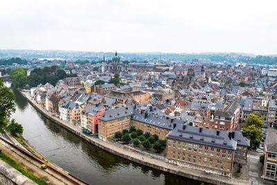 High angle view of city by river against sky