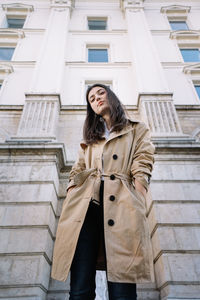 Portrait of woman standing against building