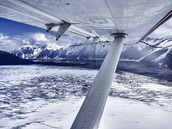 Cropped image of airplane over snow covered mountain