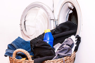 Close-up of person inserting clothes in washing machine