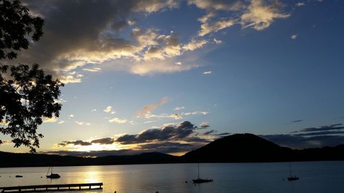 Boats in sea at sunset