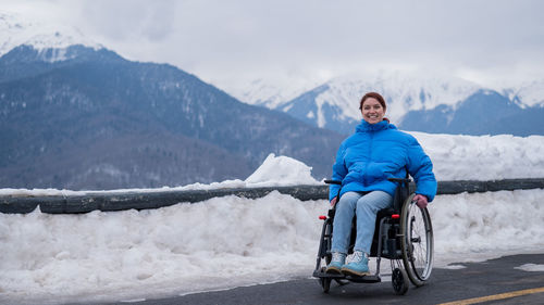 Smiling disabled woman sitting on wheelchair