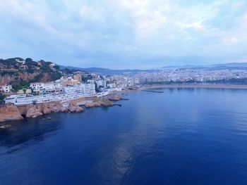 High angle view of townscape by sea against sky