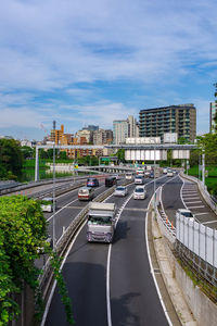 Cars on road in city against sky