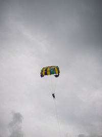 Low angle view of person parasailing against sky