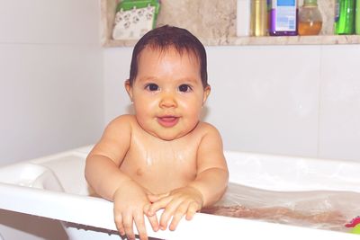 Portrait of cute baby boy in bathroom