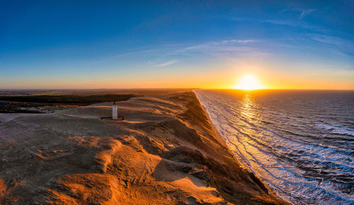 Rubjerg knude fyr lighthouse in sunset from drone