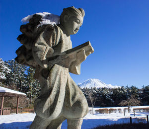 Low angle view of statue against clear blue sky