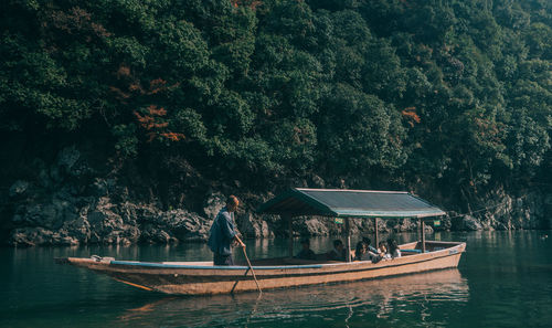 People by river against trees