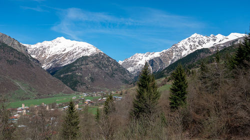 Scenic view of snowcapped mountains against blue sky