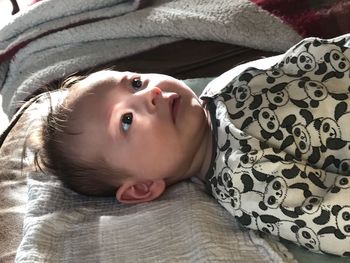 Portrait of cute baby lying on bed