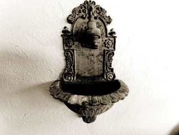 Close-up of old electric lamp against wall