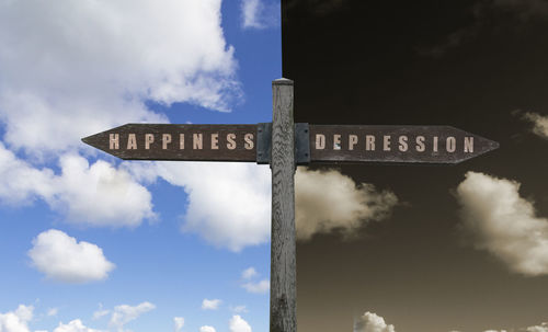Low angle view of information sign against sky