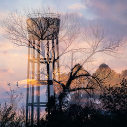 Silhouette bare tree by lake against sky during sunset