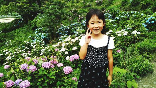 Portrait of smiling woman standing by plants