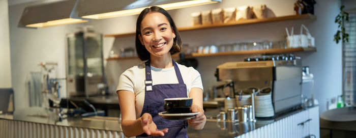 Portrait of young woman standing at home