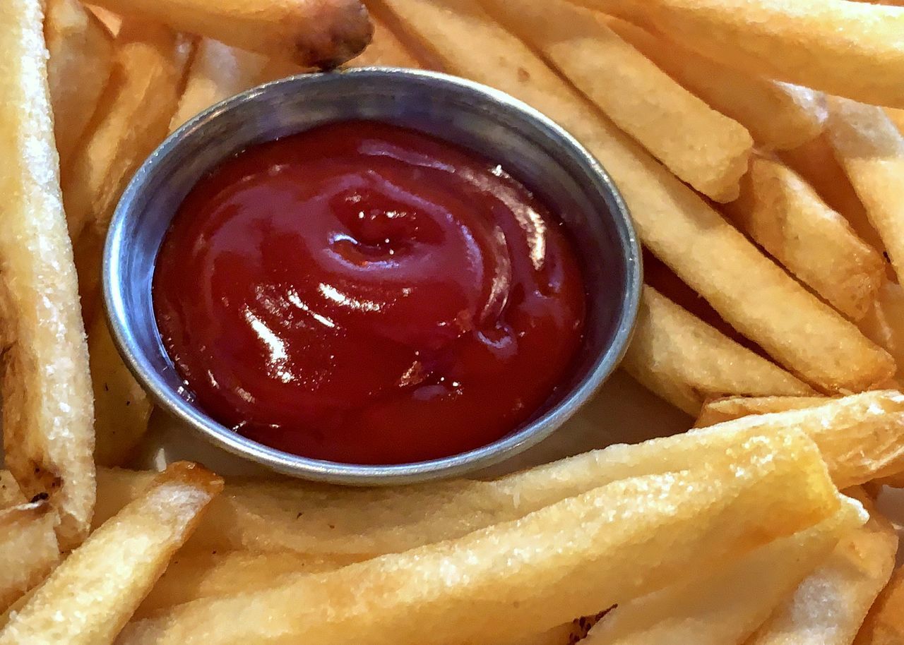 CLOSE-UP OF FRIES IN CONTAINER WITH SAUCE