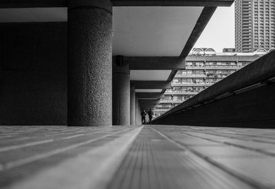 Two people in far distance, ground level brutalist architecture 