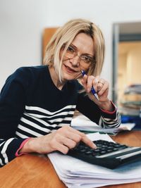 Portrait of mature woman using calculator