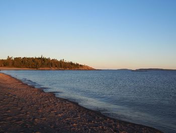 Scenic view of sea against clear sky at sunset