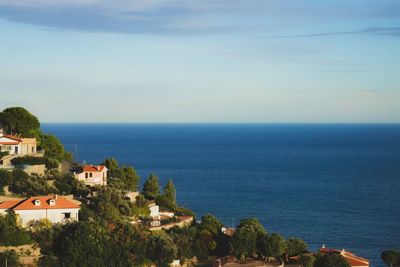 Scenic view of sea by buildings against sky