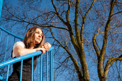 Low angle view of woman against blue sky